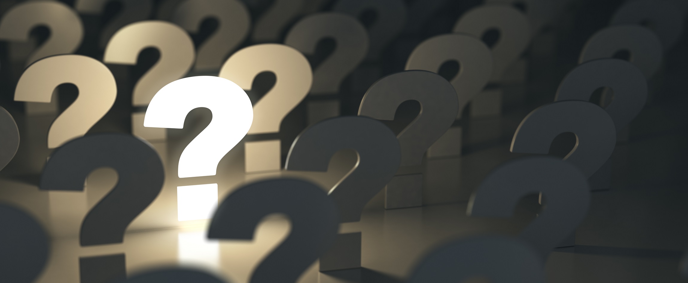 Question marks standing up, with one lit up and the others in shadow